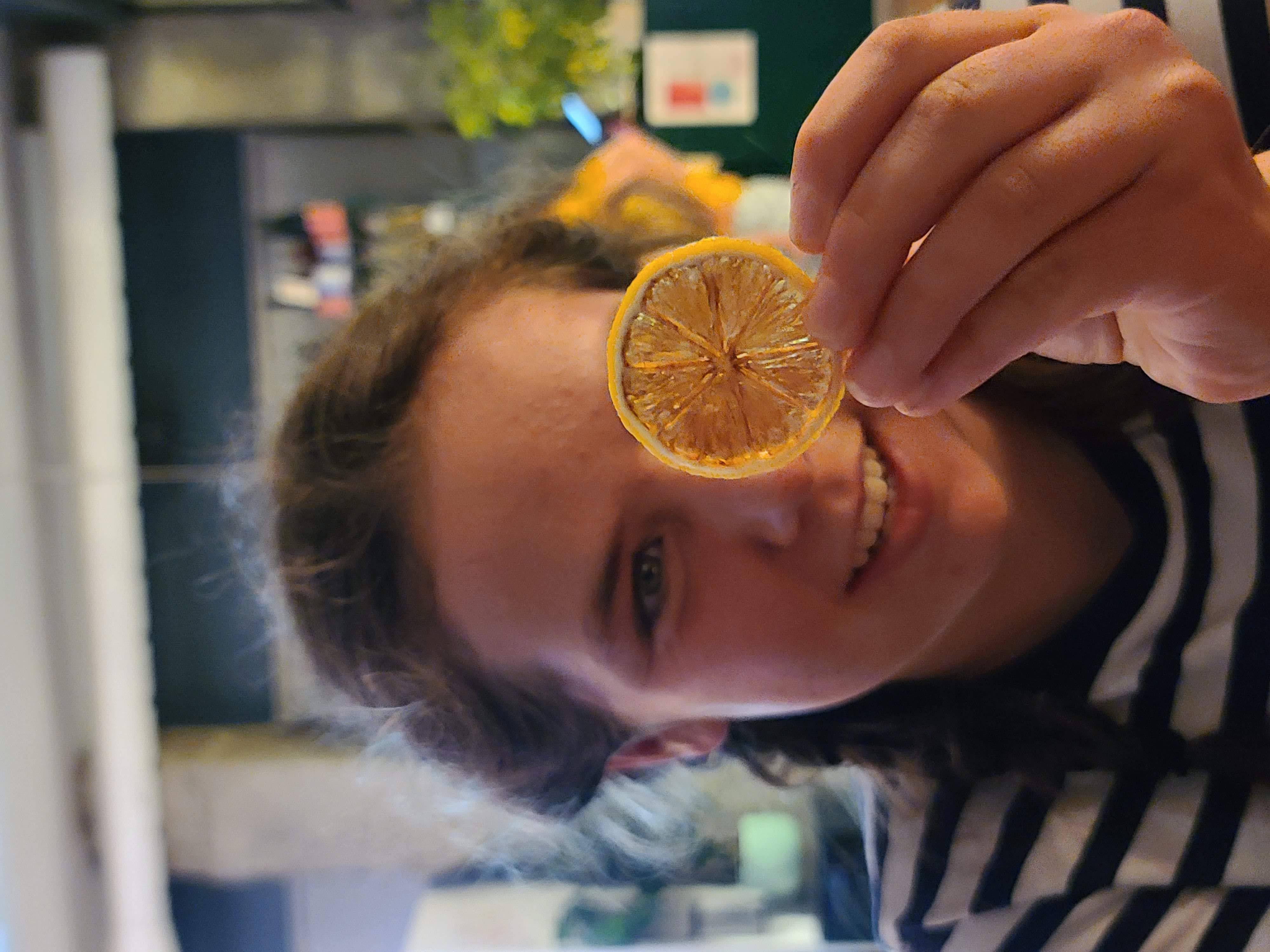 sylvia holding a slice of candied lemon, positively grinning